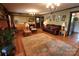 Spacious living room with hardwood floors, a brick fireplace, comfortable seating, and warm lighting at 425 Roselawn Pl, Charlotte, NC 28211