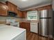 Functional kitchen featuring wooden cabinets, white appliances, and durable wood-look flooring at 4609 Coronado Dr, Charlotte, NC 28212