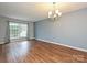 Bright living room showcasing hardwood floors, large window, and chandelier at 4609 Coronado Dr, Charlotte, NC 28212