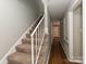 Carpeted staircase with white railing and wood flooring in the hallway at 4609 Coronado Dr, Charlotte, NC 28212