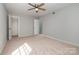 A spacious bedroom with neutral paint, a ceiling fan, a closet, and a bright window at 4609 Coronado Dr # N, Charlotte, NC 28212