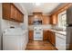 Efficient kitchen featuring classic cabinets, modern appliances, and adjacent laundry area at 4609 Coronado Dr # N, Charlotte, NC 28212