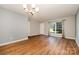A living room featuring hardwood floors, neutral walls, an elegant light fixture, and ample natural light at 4609 Coronado Dr # N, Charlotte, NC 28212