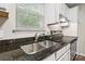 Granite countertops highlight a stainless steel sink beneath a window in this kitchen at 611 Olmsted Park Pl # C, Charlotte, NC 28203