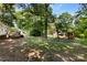 The expansive backyard showcases mature trees, a wooden deck, a playground, and a storage shed at 619 Archibald Rd, Concord, NC 28025