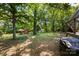 A spacious backyard boasts a well-maintained lawn, mature trees, a wooden deck, and a fun-filled playground at 619 Archibald Rd, Concord, NC 28025