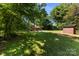 A backyard features a lush green lawn, a wooden shed, and a charming playground, offering ample space for outdoor fun at 619 Archibald Rd, Concord, NC 28025