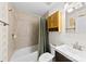 Well-lit bathroom with a combined shower and tub, light walls, and natural wood cabinet at 619 Archibald Rd, Concord, NC 28025