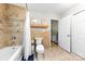 Bathroom features tiled walls, a bathtub with shower, and a neutral color scheme at 619 Archibald Rd, Concord, NC 28025