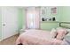 Comfortable bedroom featuring mint green walls and a twin bed with pink bedding at 619 Archibald Rd, Concord, NC 28025