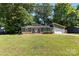 Inviting one-story home with a lush front lawn, tidy landscaping, and a convenient attached garage at 619 Archibald Rd, Concord, NC 28025