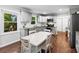 Well-lit eat-in kitchen boasts gray cabinets, stainless appliances, granite counters and hardwood floors at 619 Archibald Rd, Concord, NC 28025
