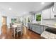 Open-concept kitchen with gray cabinets, hardwood floors, granite counters, and stainless appliances at 619 Archibald Rd, Concord, NC 28025