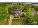 Stunning aerial view of a brick home with a well-manicured lawn and mature trees near the water at 7923 Mountain Shore Dr, Sherrills Ford, NC 28673