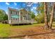 Lush backyard with deck, stone bench, and two-story home in background at 7923 Mountain Shore Dr, Sherrills Ford, NC 28673