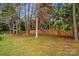 Spacious fenced backyard featuring mature trees and lush green grass at 7923 Mountain Shore Dr, Sherrills Ford, NC 28673