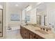 Luxurious bathroom featuring double vanity, large mirror, and soaking tub at 7923 Mountain Shore Dr, Sherrills Ford, NC 28673