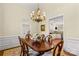 Elegant dining room with chandelier, wood table set, and view into the kitchen at 7923 Mountain Shore Dr, Sherrills Ford, NC 28673