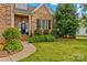 Beautiful home with a welcoming entrance, complemented by lush landscaping and a paved walkway at 7923 Mountain Shore Dr, Sherrills Ford, NC 28673