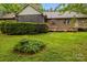View of home's brick back exterior featuring a screened porch, wood deck, and lush green lawn and shrubbery at 8368 Fairfield Forest Rd, Denver, NC 28037