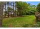 Green backyard with mature trees has a classic wood fence providing some privacy and an elevated deck at 8368 Fairfield Forest Rd, Denver, NC 28037