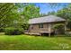 A charming brick home featuring a wood deck, beautiful lawn, and mature trees for optimal backyard privacy at 8368 Fairfield Forest Rd, Denver, NC 28037