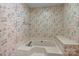 Bathroom with a jetted tub features floral wallpaper and a neutral surround at 8368 Fairfield Forest Rd, Denver, NC 28037