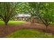 Beautiful brick home featuring a well-manicured lawn and mature trees providing shade at 8368 Fairfield Forest Rd, Denver, NC 28037