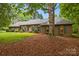 Charming brick home with green shutters, a lush lawn and mature trees at dusk at 8368 Fairfield Forest Rd, Denver, NC 28037