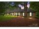 Charming brick home with green shutters, a lush lawn and mature trees at dusk at 8368 Fairfield Forest Rd, Denver, NC 28037
