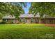 Inviting brick home with arched windows, green shutters, and a well-maintained lawn at 8368 Fairfield Forest Rd, Denver, NC 28037