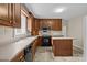 Cozy kitchen features wooden cabinets, black appliances, laminate countertops, and stone patterned tile at 8368 Fairfield Forest Rd, Denver, NC 28037