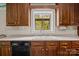 Classic kitchen with wooden cabinetry, a double sink under a window, and black appliances at 8368 Fairfield Forest Rd, Denver, NC 28037