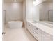 Bright bathroom featuring a large soaking tub, double vanity with white cabinets and black hardware at 9612 Pointer Rd # 59, Huntersville, NC 28078