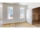 Bright bedroom with wood floors, two windows, and white door leading to additional storage space at 9612 Pointer Rd # 59, Huntersville, NC 28078