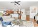 Open concept living room with hardwood floors, modern ceiling fan, and clear sight lines into the kitchen at 9930 Karras Commons Way, Matthews, NC 28105