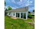 Back exterior view of home showing sunroom, level yard, and white siding at 101 Keswick Ln, Mooresville, NC 28117
