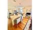 An open kitchen with stainless steel appliances, granite counters, island seating, and warm wood flooring at 101 Keswick Ln, Mooresville, NC 28117