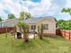 The backyard has a grill, patio, a home, and green grass at 10408 Milstead Ct, Charlotte, NC 28215