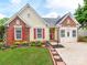 Charming single-Gathering home with a brick and vinyl facade, red shutters, and a well-manicured lawn at 10408 Milstead Ct, Charlotte, NC 28215