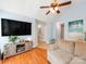 Comfortable living room featuring hardwood floors, vaulted ceilings, and a modern ceiling fan at 10408 Milstead Ct, Charlotte, NC 28215