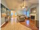 Spacious living room featuring a fireplace, ceiling fan, and hardwood flooring transitioning to tile near the dining area at 10408 Milstead Ct, Charlotte, NC 28215