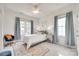 Bright bedroom with two large windows, featuring blue curtains, modern decor, and sitting chair at 117 Mills Ln, Fort Mill, SC 29708