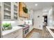 Bright kitchen featuring a professional range, custom hood, subway tile backsplash, and white cabinetry at 117 Mills Ln, Fort Mill, SC 29708