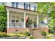 Inviting front porch with rocking chairs, complemented by brick accents and lush landscaping at 117 Mills Ln, Fort Mill, SC 29708