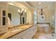 Elegant bathroom with double vanity, soaking tub, and stylish chandelier lighting at 12028 Royal Lytham Ct, Charlotte, NC 28277