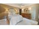 Neutral bedroom featuring a bed with an upholstered headboard, wooden dresser, and soft lighting at 12028 Royal Lytham Ct, Charlotte, NC 28277