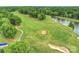 Lush aerial view of a manicured golf course featuring rolling hills, sand traps, and a scenic pond at 12028 Royal Lytham Ct, Charlotte, NC 28277