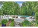 Beautiful backyard oasis with a pool, hot tub, and cozy seating area surrounded by lush greenery at 12028 Royal Lytham Ct, Charlotte, NC 28277