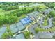 Aerial view of multiple tennis courts surrounded by lush greenery, a pond, and ample parking at 12028 Royal Lytham Ct, Charlotte, NC 28277